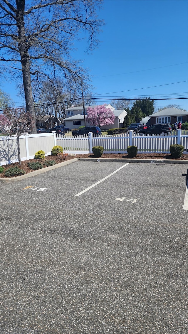 723 Carman Ave Unit 14, Westbury, NY 11590 - uncovered parking lot featuring a fenced front yard