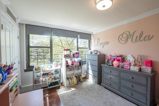 playroom with crown molding, healthy amount of natural light, and wood finished floors