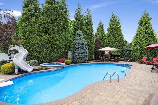 7 Moreland Ct, Mount Sinai, NY 11766 - view of swimming pool with a water slide, a patio area, a diving board, and a pool with connected hot tub
