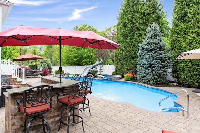 7 Moreland Ct, Mount Sinai, NY 11766 - view of pool featuring a water slide, a fenced backyard, a patio, and a pool with connected hot tub
