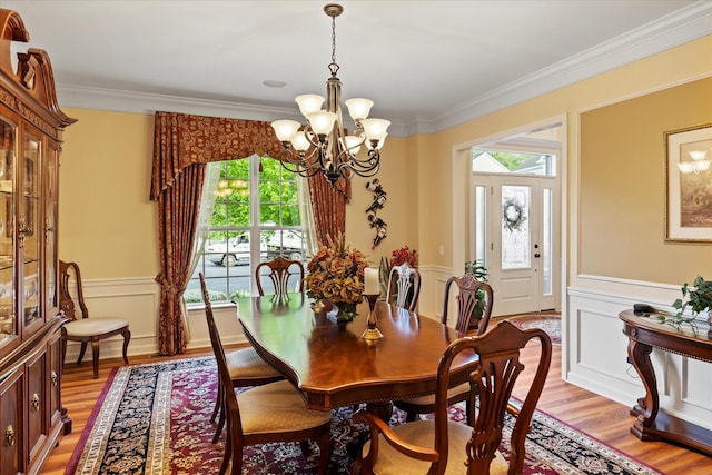 7 Moreland Ct, Mount Sinai, NY 11766 - dining room with plenty of natural light, ornamental molding, a chandelier, light wood-style floors, and wainscoting