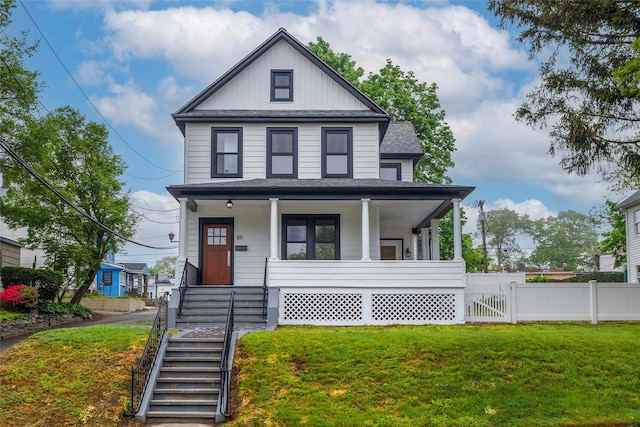 view of front of home featuring a shingled roof, a porch, fence, and a front yard