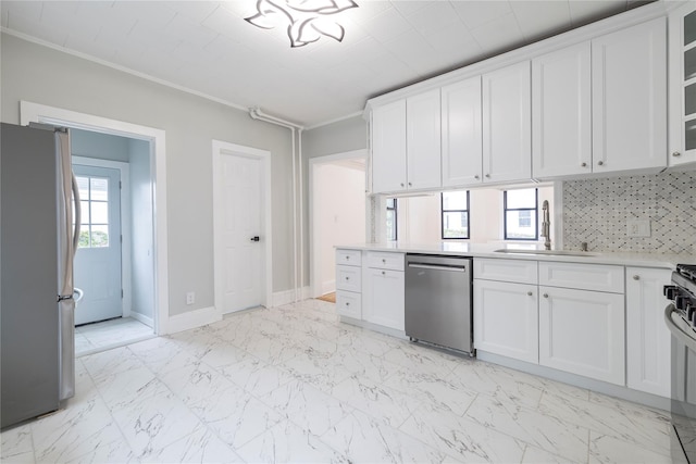 kitchen featuring a sink, stainless steel appliances, tasteful backsplash, white cabinetry, and light countertops
