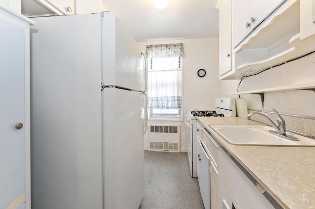 kitchen featuring white appliances, radiator, a sink, white cabinets, and light countertops
