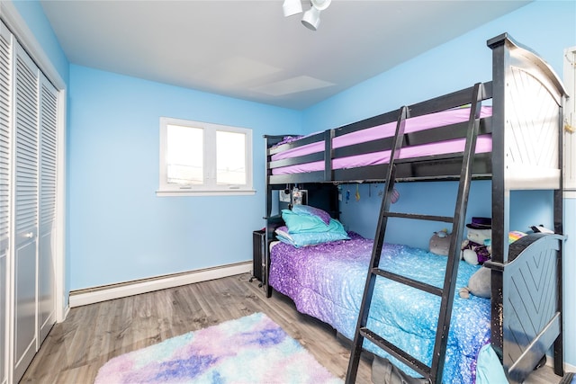 585 Nassau Ave, Freeport, NY 11520 - bedroom featuring a baseboard radiator, wood finished floors, baseboards, and a closet