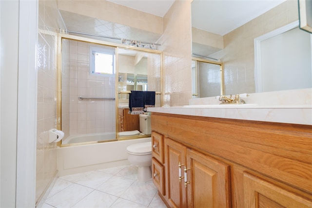 585 Nassau Ave, Freeport, NY 11520 - bathroom with toilet, combined bath / shower with glass door, vanity, tile patterned flooring, and tile walls