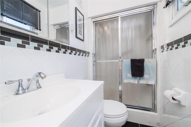 585 Nassau Ave, Freeport, NY 11520 - full bathroom with tile walls, a stall shower, toilet, and vanity
