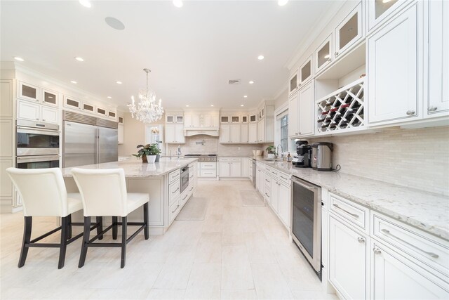 kitchen featuring built in appliances, wine cooler, a sink, recessed lighting, and a large island with sink
