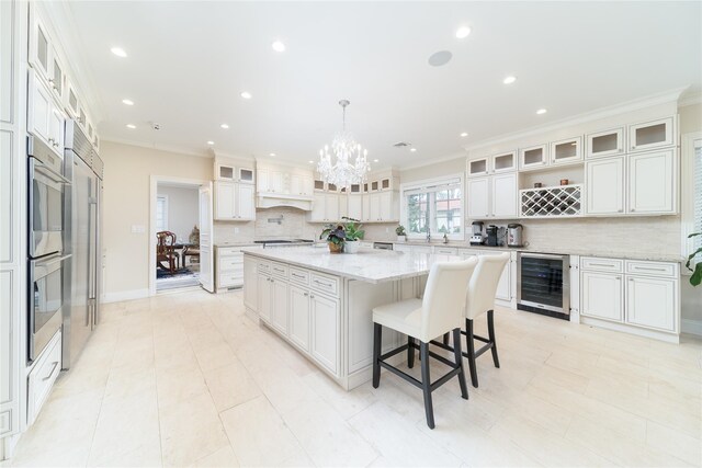 kitchen with wine cooler, tasteful backsplash, a spacious island, white cabinets, and a chandelier