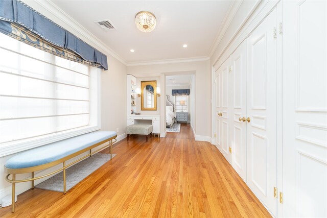 hallway featuring plenty of natural light, baseboards, light wood-type flooring, ornamental molding, and recessed lighting