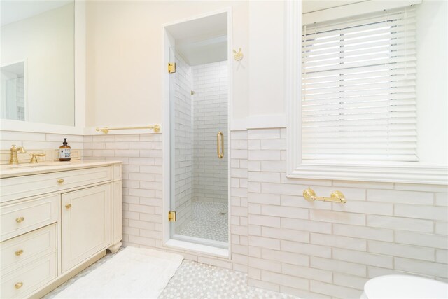 full bath with a shower stall, tile walls, vanity, toilet, and wainscoting