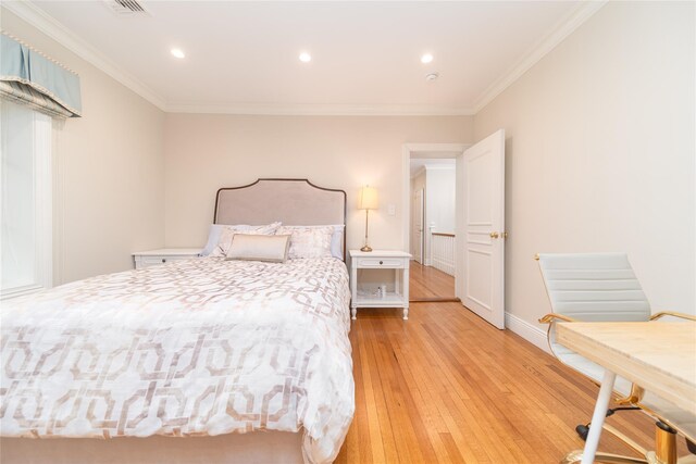 bedroom featuring crown molding, light wood-type flooring, recessed lighting, and baseboards