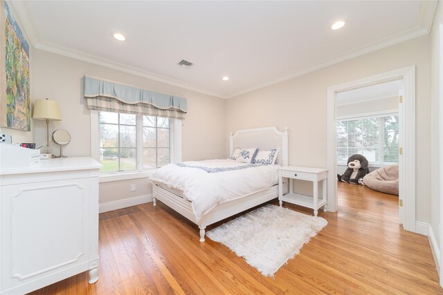 bedroom featuring multiple windows, light wood-style floors, crown molding, recessed lighting, and baseboards