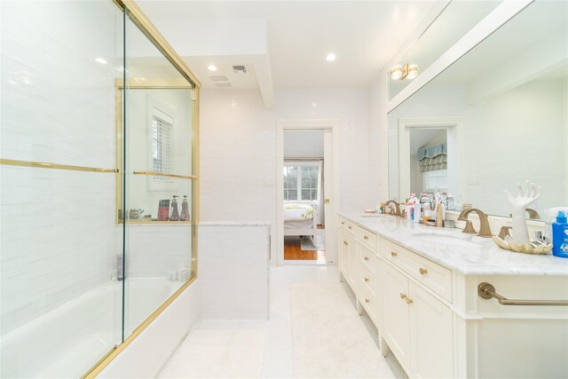 full bathroom with ensuite bathroom, double vanity, combined bath / shower with glass door, recessed lighting, and tile patterned flooring