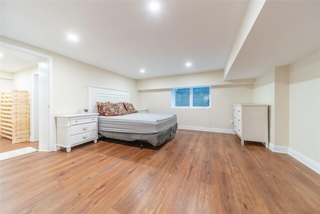 bedroom with light wood finished floors, baseboards, and recessed lighting