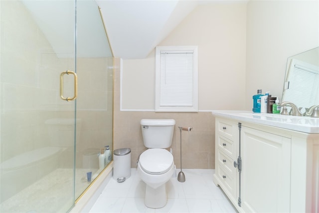 bathroom featuring vaulted ceiling, toilet, a stall shower, tile walls, and vanity