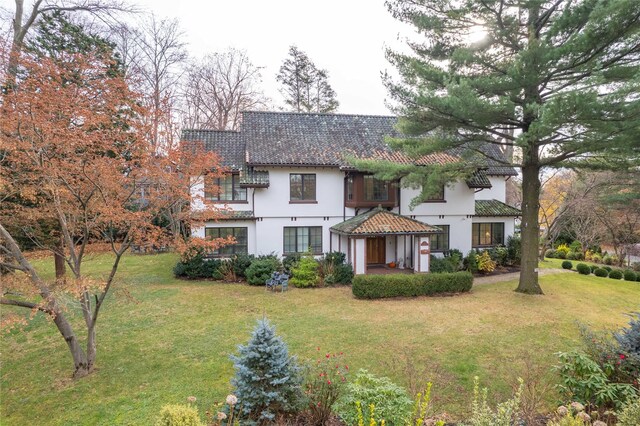 mediterranean / spanish house with stucco siding and a front yard