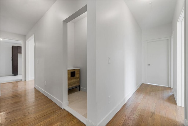 hallway featuring wood finished floors and baseboards