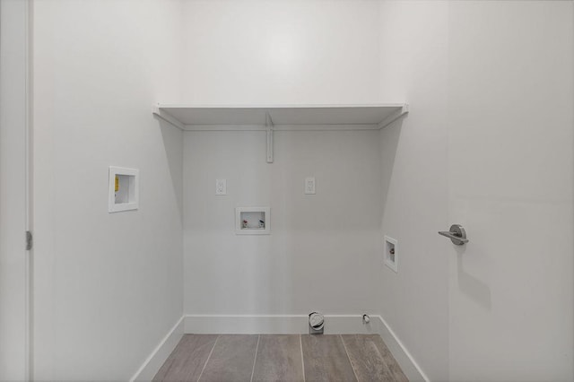 laundry area featuring gas dryer hookup, hookup for a washing machine, baseboards, wood finished floors, and hookup for an electric dryer