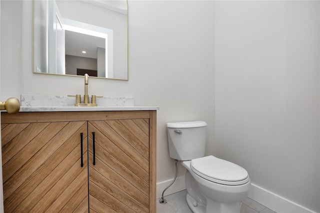 half bathroom with tile patterned flooring, baseboards, toilet, and vanity