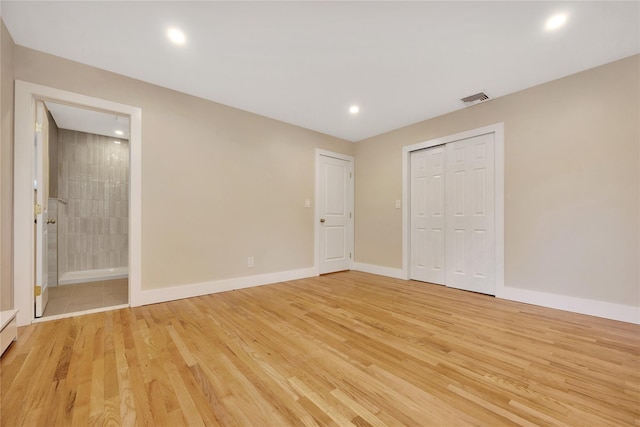 unfurnished bedroom featuring light wood finished floors, recessed lighting, baseboards, ensuite bath, and a closet