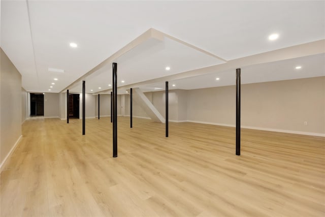 finished below grade area featuring light wood-style floors, baseboards, and recessed lighting