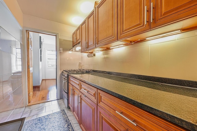 372 Grand Ave, Brooklyn, NY 11238 - kitchen featuring stainless steel range with gas stovetop, under cabinet range hood, and brown cabinets