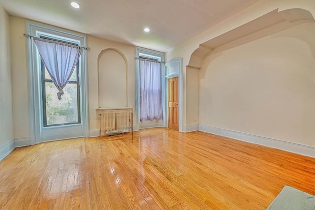 372 Grand Ave, Brooklyn, NY 11238 - unfurnished room featuring wood finished floors, radiator, baseboards, recessed lighting, and arched walkways