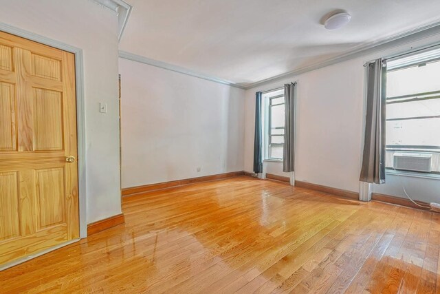 372 Grand Ave, Brooklyn, NY 11238 - spare room featuring light wood-style floors, ornamental molding, cooling unit, and baseboards