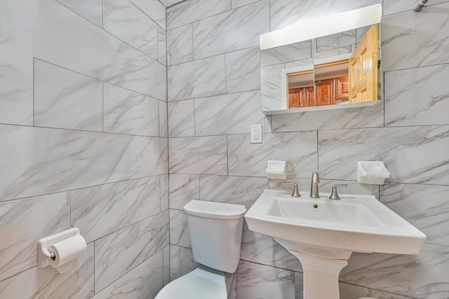 372 Grand Ave, Brooklyn, NY 11238 - bathroom with tile walls, toilet, decorative backsplash, and a sink