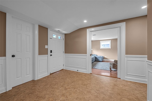 foyer entrance featuring wainscoting, a decorative wall, and recessed lighting