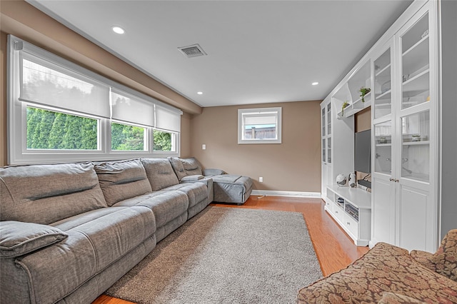 living room featuring light wood-style flooring, plenty of natural light, baseboards, and recessed lighting