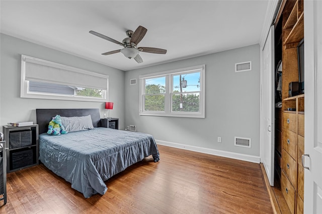 bedroom with wood finished floors, baseboards, and a ceiling fan