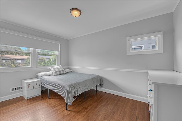 bedroom with baseboards and wood finished floors