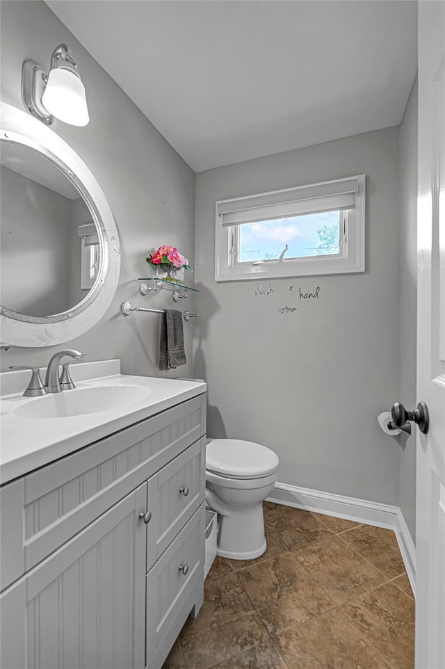bathroom featuring vanity, toilet, and baseboards