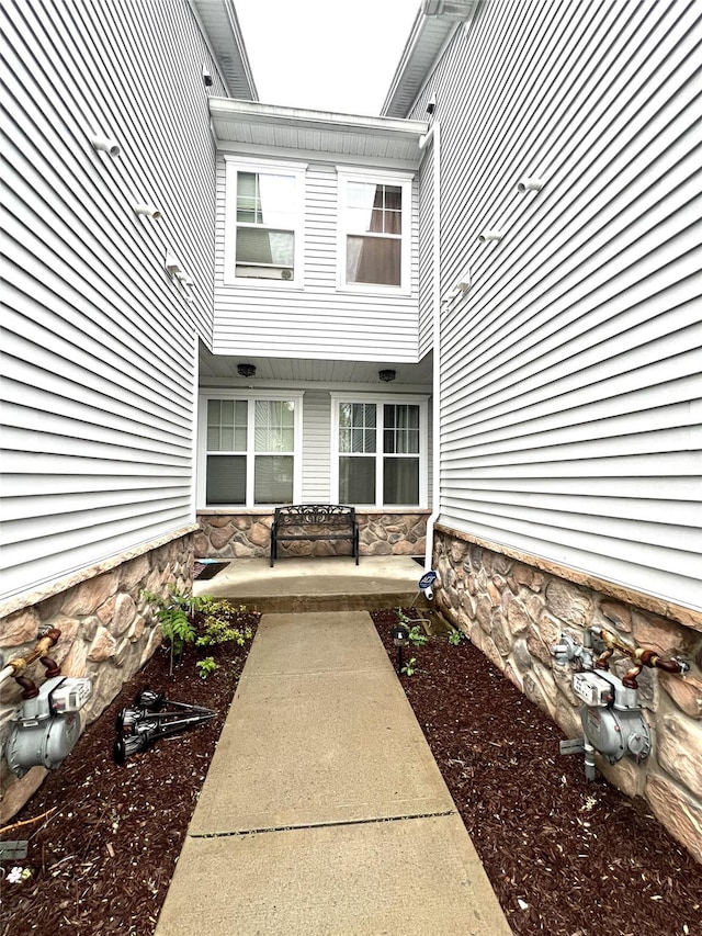 property entrance with stone siding and a porch