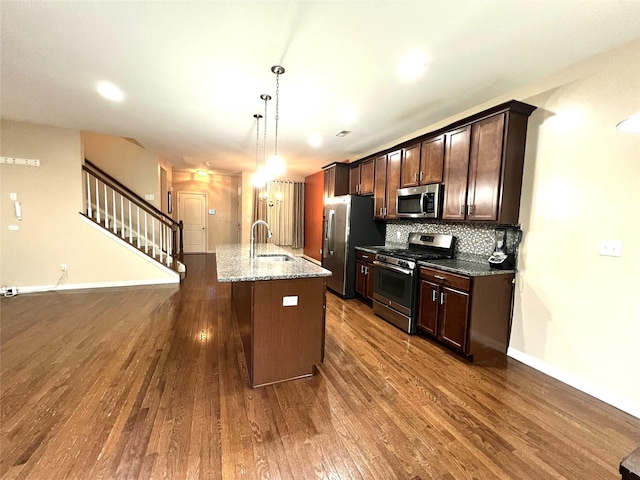 kitchen with dark wood-style flooring, appliances with stainless steel finishes, a sink, and dark brown cabinetry