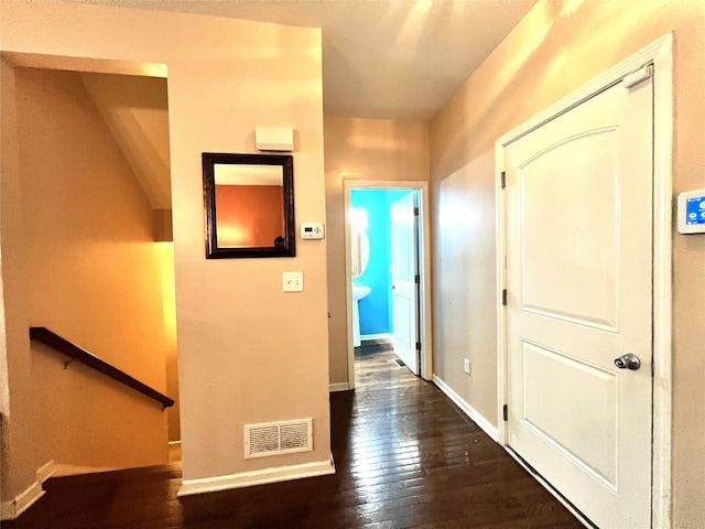 hallway with baseboards, dark wood finished floors, and visible vents