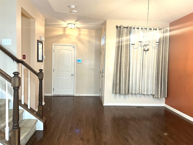foyer with baseboards, a notable chandelier, and wood finished floors