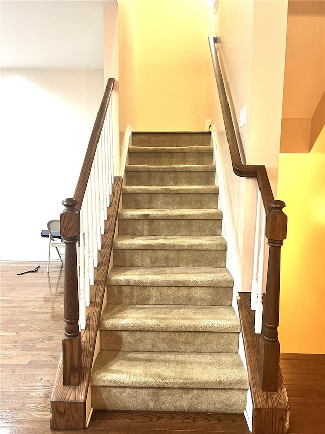 stairs featuring wood finished floors