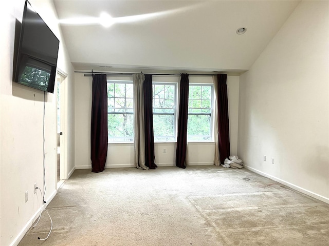 unfurnished room featuring carpet flooring, plenty of natural light, and lofted ceiling