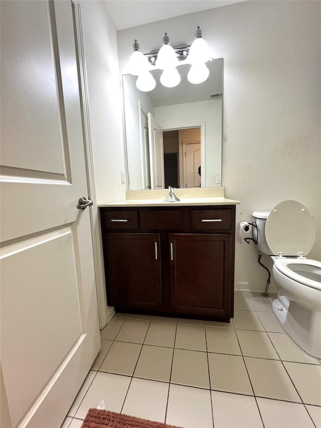 half bathroom with tile patterned floors, toilet, visible vents, and vanity