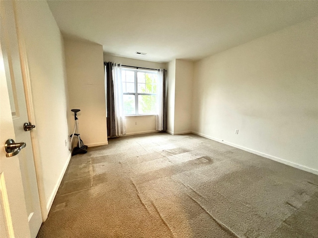 spare room with baseboards, carpet flooring, and visible vents