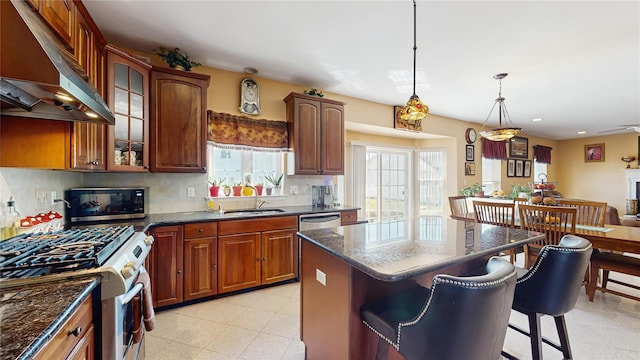 2041 Independence Dr, New Windsor, NY 12553 - kitchen featuring stainless steel gas range, under cabinet range hood, a sink, a kitchen bar, and glass insert cabinets