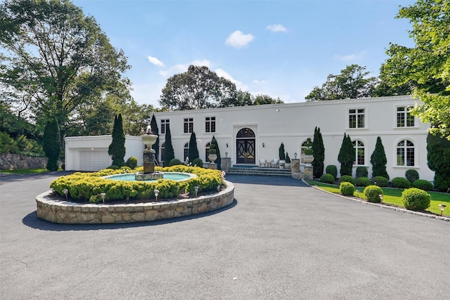 65 Round Hill Rd, Armonk, NY 10504 - view of front of home featuring driveway, stucco siding, and an attached garage