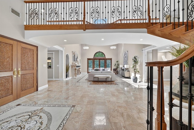 65 Round Hill Rd, Armonk, NY 10504 - entrance foyer with light marble finish floors, a towering ceiling, stairway, recessed lighting, and arched walkways