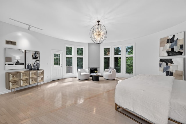 65 Round Hill Rd, Armonk, NY 10504 - bedroom with wood-type flooring, a chandelier, and a fireplace