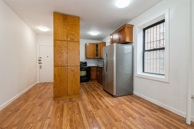 62-64 Saunders Unit K2, Rego Park, NY 11374 - kitchen with stainless steel fridge with ice dispenser, black gas stove, brown cabinetry, and light wood finished floors
