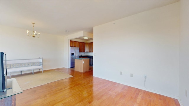 6910 Beach Front Rd, Arverne, NY 11692 - unfurnished living room with a chandelier, light wood-style flooring, and baseboards