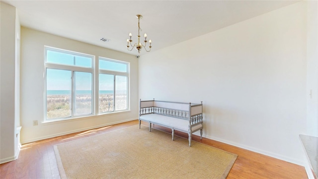 6910 Beach Front Rd, Arverne, NY 11692 - sitting room with wood finished floors, a chandelier, and baseboards